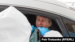 Тиббиёт ходими Олмаотада коронавирусга тест олмоқда.