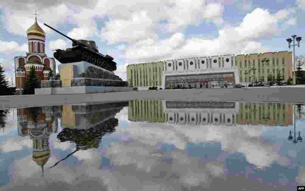 Russia -- The square of giant "Uralvagonzavod" plant, a producer of the 47 tonnes of heavy metal and hi-tech T-90S tank, with an acting WW II historic T-34 tank foreground, Nizny Tagil, May 17, 2006