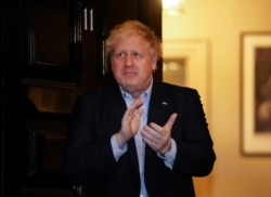 Premierul Boris Johnson, la reședința sa, aplaudând medicilor și celor din prima linie în lupta cu pandemia, 2 aprilie 2020