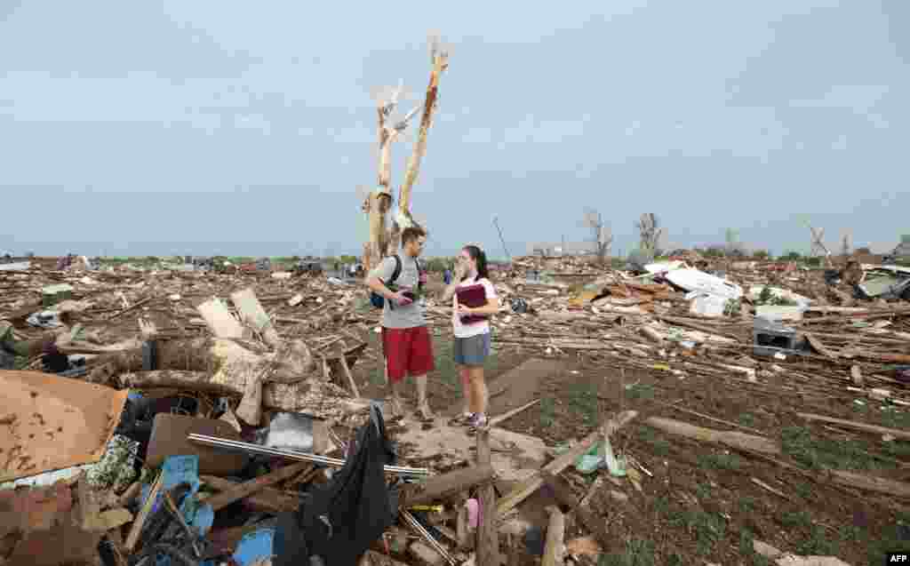 Carlos and Kim Caudillo stand amid the debris of their home.