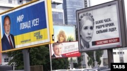 Kiyevdə prezidentliyə namizədlər (soldan-sağa) Serhiy Tihipko, Petro Poroshenko və Yulia Tymoshenkonun seçki plakatları. 20 may 2014