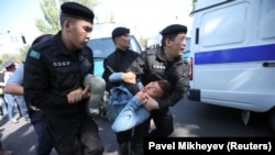 Сотрудники спецподразделения полиции несут задержанного в автозак. Алматы, 21 сентября 2019 года.