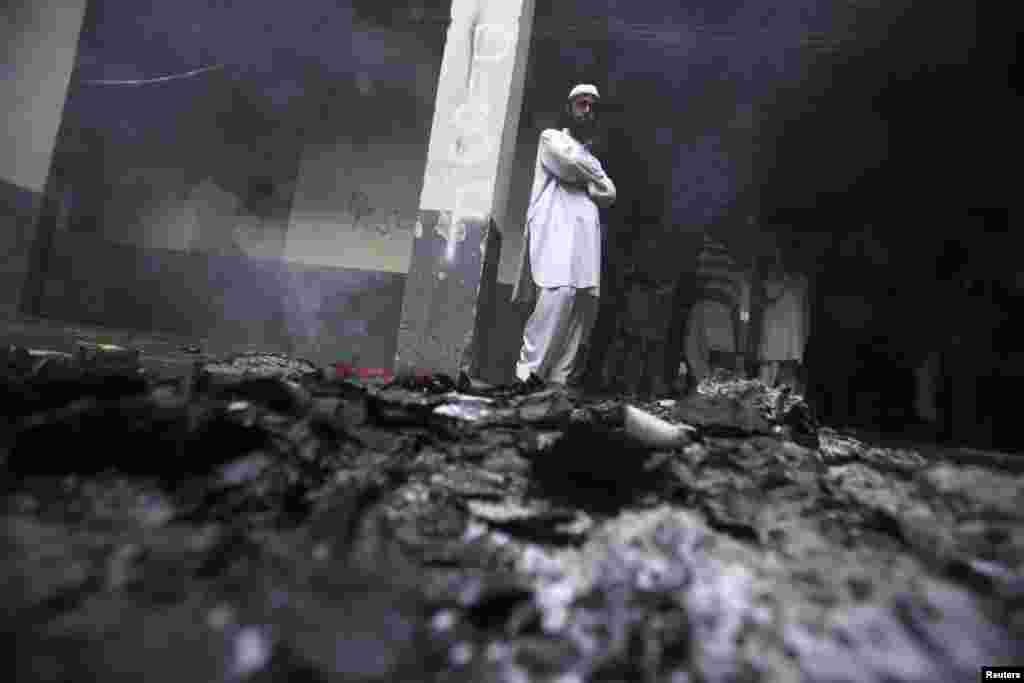 A student stands near ashes in a hostel room after it was torched during a clash between two student groups at Peshawar University on Valentine's Day. (Reuters/Fayaz Aziz)