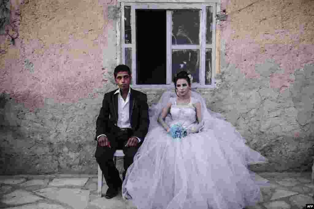 A newly married couple poses at home in the war-torn city of Kobani in northern Syria. (AFP/Yasin Akgul)