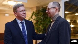 Глава ведомства Европейского союза по вопросам расширения Штефан Фюле (cлева) и украинский оппозиционер, один из лидеров партии "Батькивщина", Арсений Яценюк. Киев, 11 февраля 2014 года.