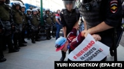 Полицейские задерживают участника митинга. Москва, 27 июля 2019 года
