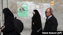 Иран- пешаци поминуваат покрај изборни плакати за престојните парламентарни избори