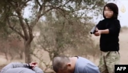 Кадр пропагандистского видео исламистов, на котором мальчик-боевик Абдулла, предположительно из Казахстана, расстреливает двух мужчин, обвиненных в шпионаже против экстремистской группировки «Исламское государство».