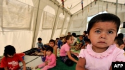 Local children play inside a tent on the outskirts of Osh in late August.