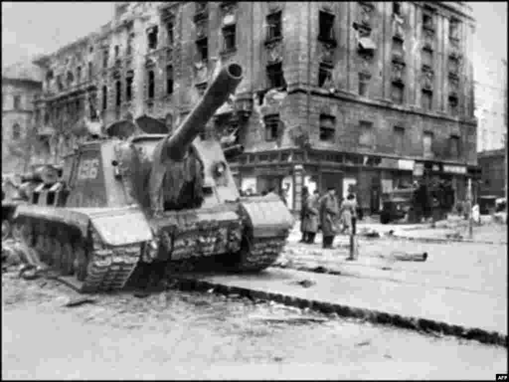 Budapeşt üzägendä Sovet Armiäse tankı, 12 Noyaber 1956 (AFP) - 1956 yılnıñ Üktäber-Noyaberendä macarlar sovet xakimiätenä qarşı baş kütärä. Bäreleşlärdä berniçä meñ macar häm 750 sovet xärbie häläq bula. 200 meñläp macar ilennän qaça, 13 meñläp keşe uñışsız tämamlanğan baş kütärüdä qatnaşqan öçen törmälärgä yabıla. 