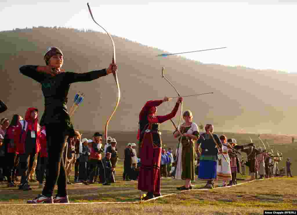 An arrow flies from the bow of Ayana Rustam (left), from Kyrgyzstan, alongside other competitors during one of the standing archery events.