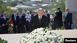 Orsýetiň prezidenti Wladimir Putin Özbegistanyň öňki prezidenti Yslam Kerimowyň mazaryna gül goýýar, Samarkant, 6-njy sentýabr, 2016.