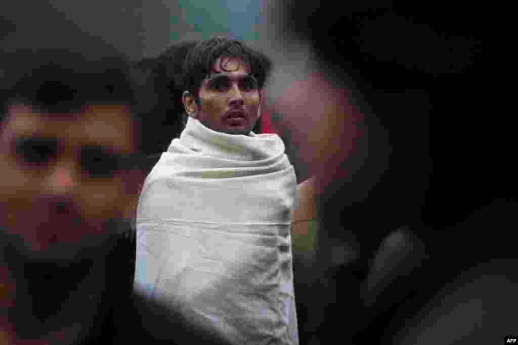 A migrant looks on as he wears a blanket on him during the evacuation of the Jardin d'Eole camp, in Paris on June 6. (AFP/Geoffroy Van der Hasselt)