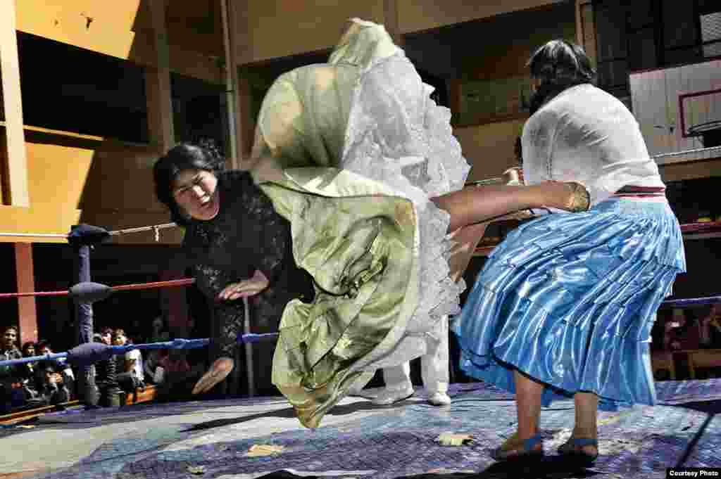 2-е место / Искусство и развлечения / серии Даниэле Таманьи, Италия Летящие Cholitas, Боливия: Вольная борьба, или la lucha libre, одно из самых популярных зрелищ в Боливии. За последние 10 лет участием в борьбе прославились женщины-борцы Cholitas. Здесь: Кармен Роза и Джулия ля Пасенья участвуют в благотворительном выступлении на школьном дворе. Боливия, 26 июня 2010. 