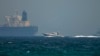 An Emirati coast guard vessel passes an oil tanker off the coast of Fujairah, May 13, 2019. FILE PHOTO