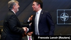 Yunanıstanın NATO-dakı səfiri Spiros Lambridis (solda) Makedoniya xarici işlər naziri Nikola Dimitrovu təbrik edir