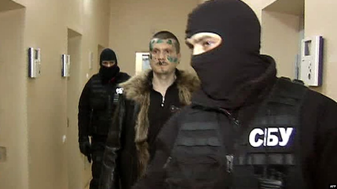Adam Osmayev walks under escort of masked agents of the Ukrainian Security Service in Odesa.