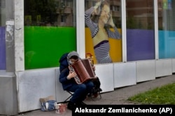 A woman plays accordion for money just outside Moscow in May.