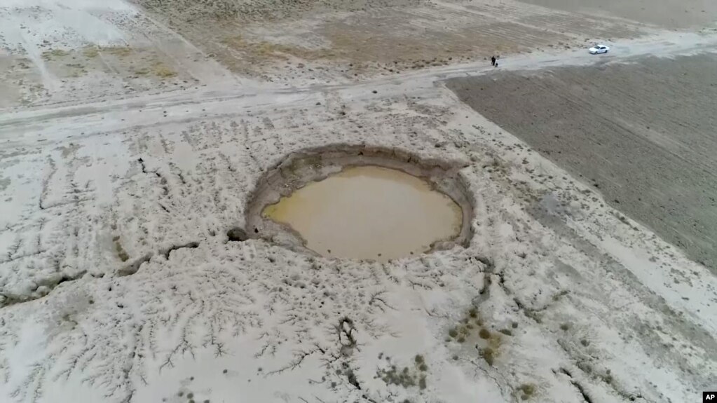 Iran - a sinkhole caused by land subsidence, caused by excessive ground water usage, caused by drought. AP video screen grab