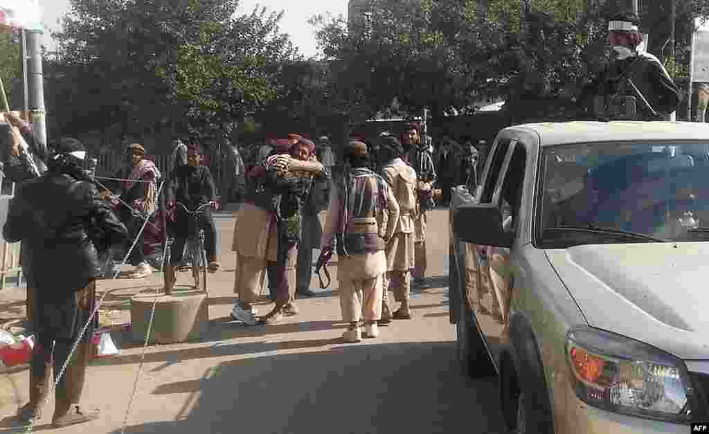 Taliban fighters hug each other after they overran the strategic northern city of Kunduz.