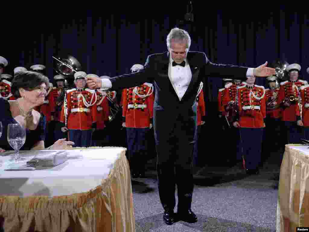 U.S. President George W. Bush (C) takes a bow after conducting the Marine Band rendition of Stars and Stripes Forever at the annual White House Correspondents Association dinner in Washington, April 26, 2008. REUTERS/Jonathan Ernst 