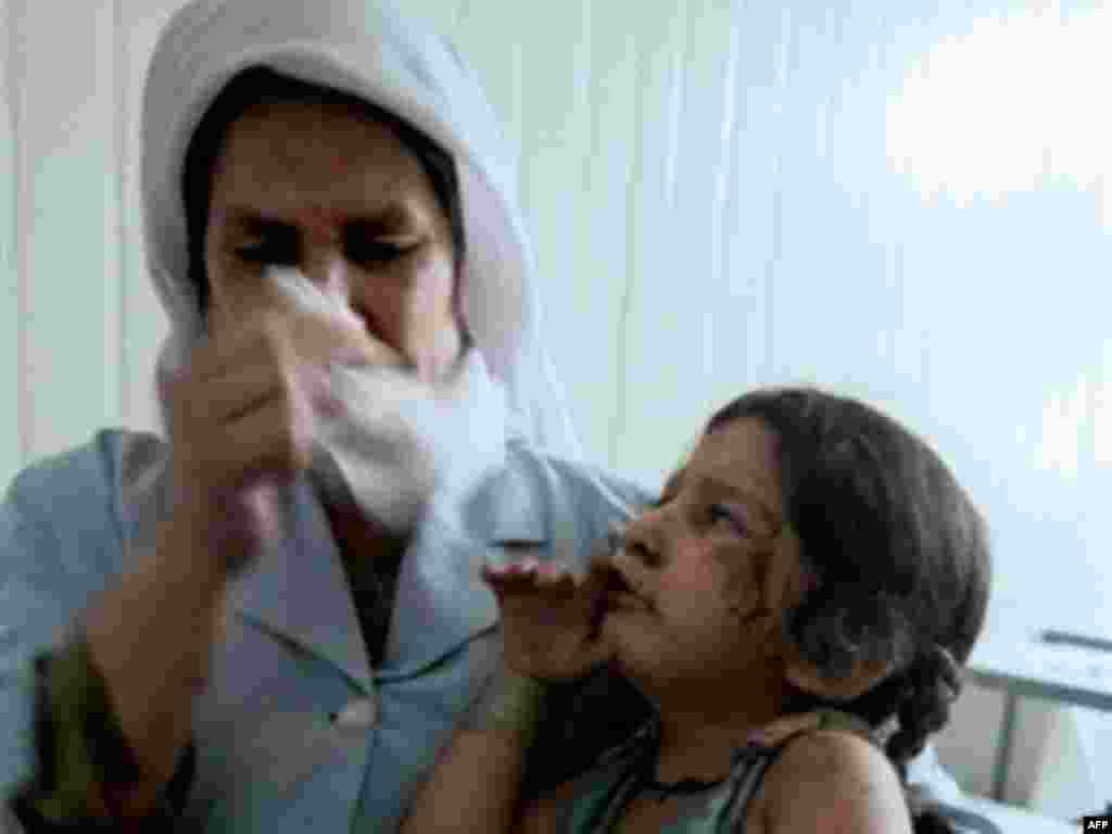 Медсестра одно из кабульских больниц плачет над раненой во время теракта девочкой