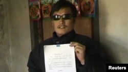 Қытайдағы құқық қорғаушы Чэнь Гуанчен үкіметке қарсы жазған петициясын ұстап тұр. Қытай, Шаньдун провинциясы, 27 сәуір 2012 жыл. 