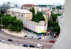 Вигляд на «будинок з балконом Грушевського» (закритий будівельним банером) із дзвіниці Софії Київської. Київ, червень 2018 року