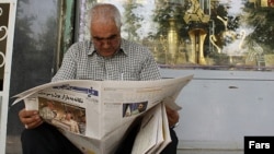 Iran, Tehran -- A man reads a newspaper