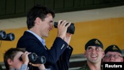 Прем’єр-міністр Канади Джастін Трюдо разом із сином спостерігає за військовими навчаннями на Яворівському полігоні. 12 липня 2016 року