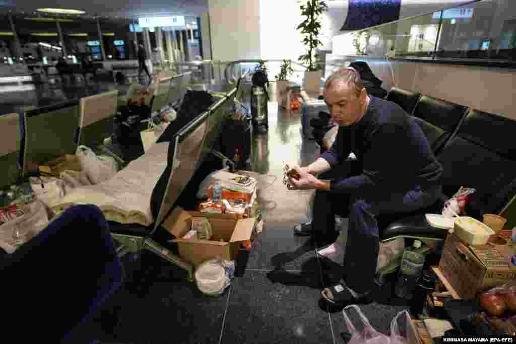 A Russian man eats amid boxes of food at Tokyo International Airport.