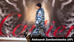 Полицейский кинолог с собакой ищут бомбу в ГУМе, архивное фото