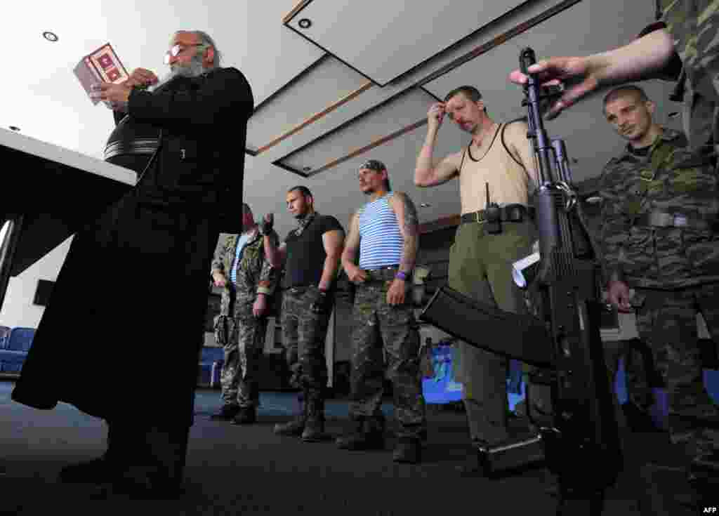 An Orthodox priest holds a service as pro-Russian militants pray in the village of Senyonovka, near the eastern city of Slovyansk, Ukraine. (AFP/Viktor Drachev)