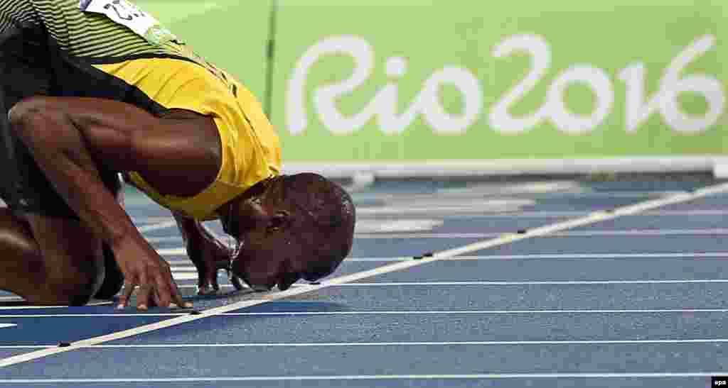 Usain Bolt of Jamaica kisses the track after winning the men&#39;s 200m final.