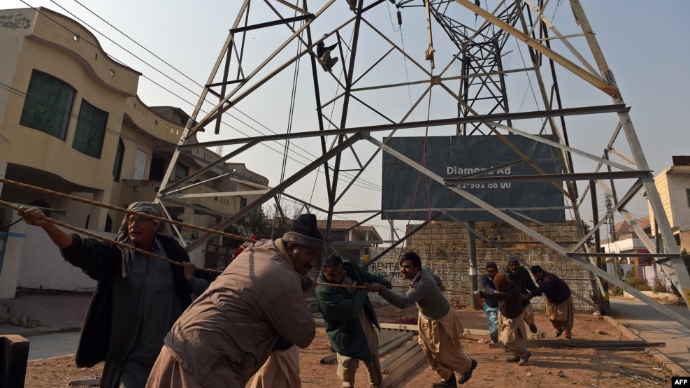 Pakistani workers complete a high-voltage power pole in Rawalpindi. (file photo)