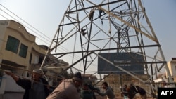 Pakistani workers complete a high-voltage power pole in Rawalpindi. (file photo)