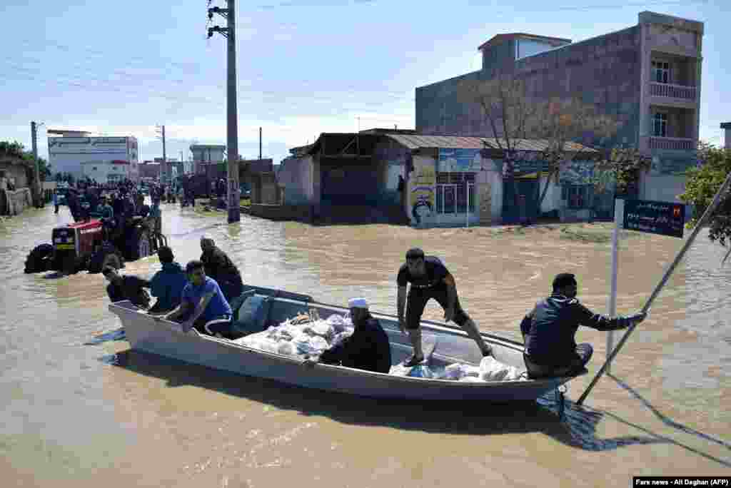 Residents of the northern Iranian village Agh Ghaleh are using a boat in a flooded street, on March 23, 2019. &nbsp;