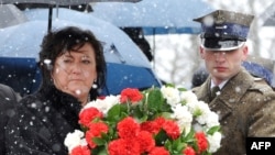 Polish first lady Anna Komorowska prepares to lay flowers at the monument for the 96 victims of the April 2010 plane crash during a memorial service at the Smolensk aerodrome, the site of the disaster.