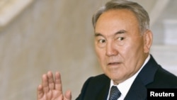 Kazakh President Nursultan Nazarbaev waves to media as he walks to meet his Chinese counterpart in Astana 