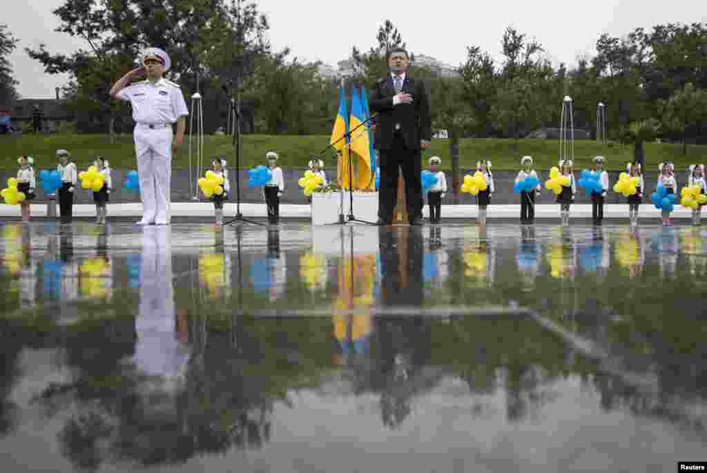 Президент Петр Порошенко слушает национальный гимн во время Дня независимости Украины в порту Одессы. 