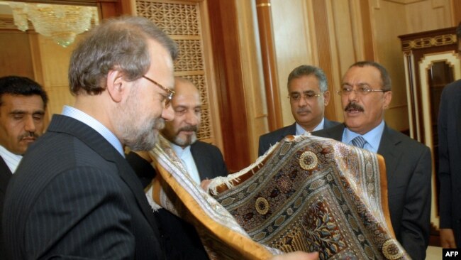 Iranian Parliament Speaker Ali Larijani (L) offers Yemeni President Ali Abdullah Saleh (R) a Persian carpet during their meeting in Sanaa on May 14, 2009. Larijani is on an official visit to neighbouring Yemen. AFP PHOTO/KHALED FAZAA / AFP PHOTO / KHALED