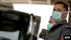 Oficerët e policisë malazeze mbajnë maska ​​mbrojtëse në pikën kufitare midis Malit të Zi dhe Shqipërisë, më 15 mars 2020.
