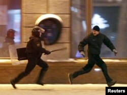 A riot policeman chases an opposition protester during a rally denouncing the results of the presidential election in central Minsk on December 19, 2010.