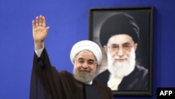 I Президент Ирана Хасан Роухани на фоне портрета Верховного лидера Ирана аятоллы Али Хаменеи.