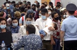 Новосибирск әуежайынан Өзбекстанға ұшу үшін төлқұжаттарын тексертіп тұрған өзбек мигранттары. 23 мамыр 2020 жыл.