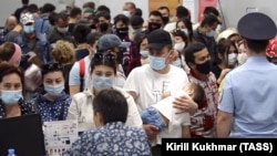 Узбекские мигранты в масках стоят в очереди в аэропорту Толмачево под Новосибирском, чтобы пройти регистрацию на эвакуационный рейс авиакомпании «Узбекистон хаво йуллари» в Ташкент, 23 мая 2020 г. 