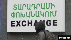 Armenia - A schoolboy walks past a currency exchange sign in Yerevan, 17Dec2014.