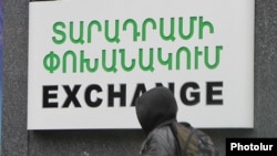 Armenia - A schoolboy walks past a currency exchange sign in Yerevan, 17Dec2014.