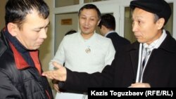 Серік Ембергенов (сол жақ шетте) Сәкен Шардаровпен (оң жақ шетте) сөйлесіп тұр. Алматы, 4 қаңтар 2012 жыл.