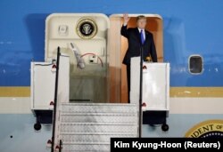 U.S. President Donald Trump waves upon his arrival at Paya Lebar Air Base in Singapore on June 10.